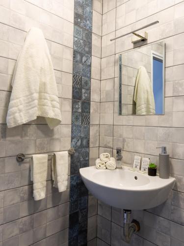 ein Badezimmer mit Waschbecken, Spiegel und Handtüchern in der Unterkunft La Piazza Hotel in Schumen