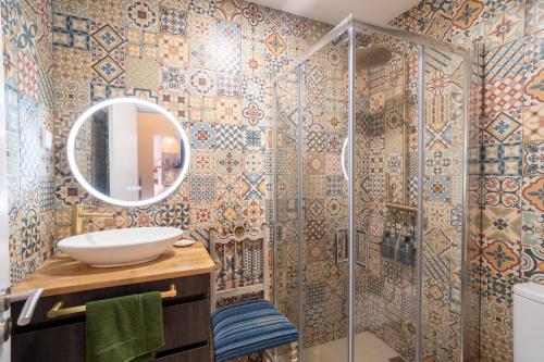 a bathroom with a shower with a sink and a mirror at Sunrise House by Wanderlust Madeira - 2 Bedroom Sea View in Gaula