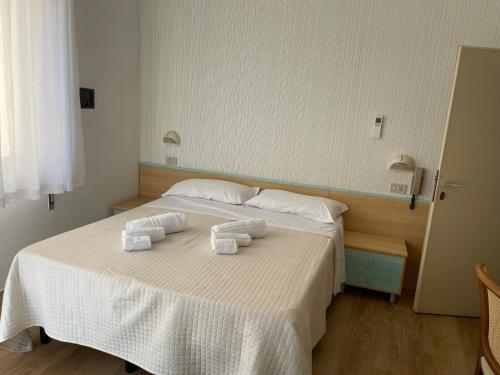 a bedroom with a bed with towels on it at Hotel Barbiani in Riccione