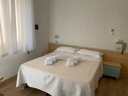 a bedroom with a large bed with towels on it at Hotel Barbiani in Riccione