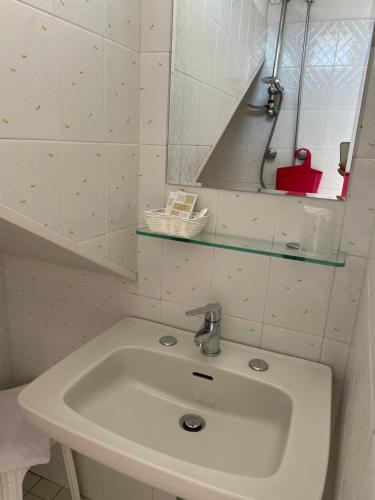a white sink in a bathroom with a mirror at Hotel Barbiani in Riccione
