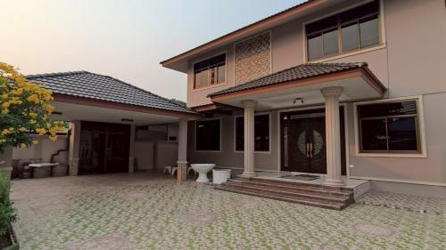 a house with a porch with a toilet in front of it at Private 2-storey house in Chiang Mai By The Orchard in Chiang Mai