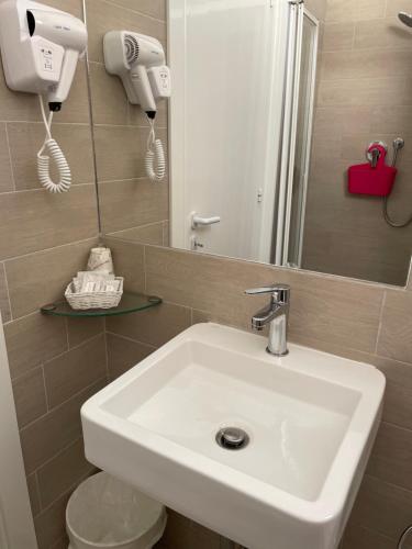 a bathroom with a white sink and a mirror at Hotel Barbiani in Riccione