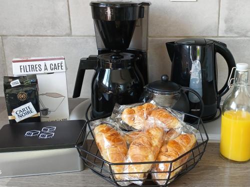 een mandje croissants op een aanrecht naast een blender bij La maisonnette in Cléry-Saint-André