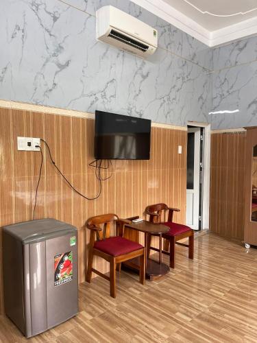 a room with a table and chairs and a tv at Thiên Nam Motel Đà Nẵng in Da Nang