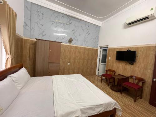 a bedroom with a bed and a table and a tv at Thiên Nam Motel Đà Nẵng in Da Nang