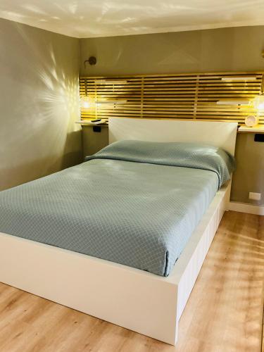 a bedroom with a large bed with a white frame at CityLoft Milano, two meters from metro station for the Duomo in Milan