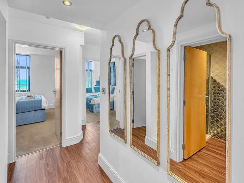 a room with mirrors and a bedroom with a bed at Granada Apartments Berkeley in Blackpool