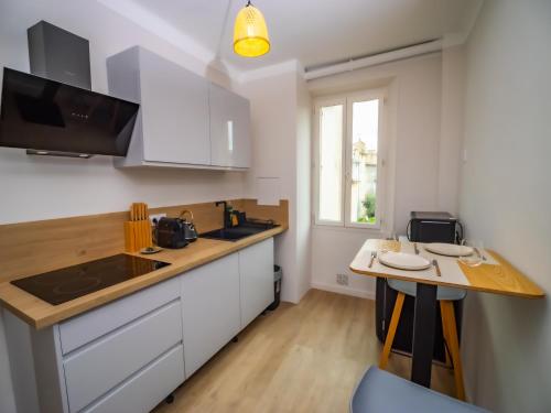 une cuisine avec des armoires blanches et un comptoir en bois dans l'établissement #302-Heart of Vieil Antibes - Place Nationale-High-End Newly Renovated & Furnished Appartment, à Antibes