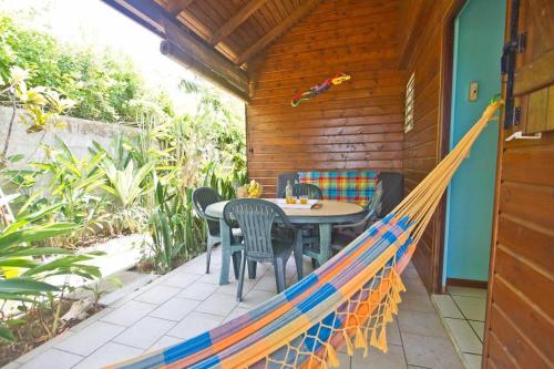a hammock on a patio with a table and chairs at Gwada Dream in Sainte-Anne
