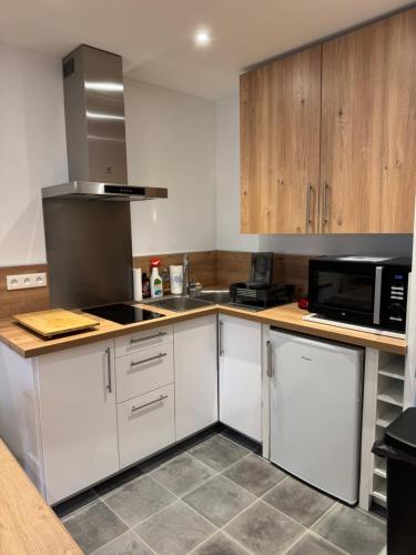 La cuisine est équipée de placards blancs et d'un four micro-ondes noir. dans l'établissement Studio proche des pistes - Chantegrive, à Uvernet