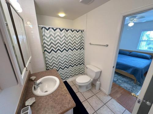 a bathroom with a sink and a toilet and a bed at KD108- Into the Mystic in Kill Devil Hills