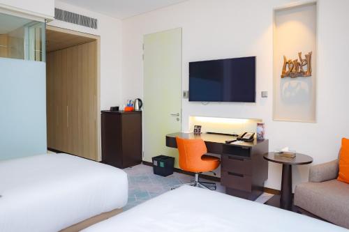 a hotel room with a desk and a bed at Le Meridien City Centre Bahrain in Manama