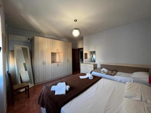 ティラナにあるHotel Bujtina Shqiptareのタオルが敷かれた大きなベッドのある寝室