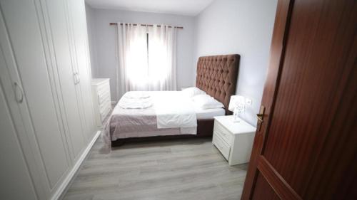 een kleine slaapkamer met een bed en een raam bij Hotel Bujtina Shqiptare in Tirana