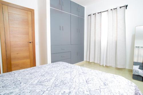 a white bedroom with a bed and a closet at 2BR, Private Pool, Modern, Close to Beach in Las Terrenas