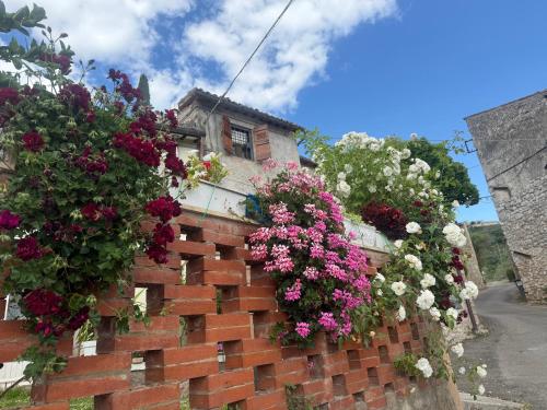 a brick retaining wall with flowers on it at Athena Casa Vacanze in Campello sul Clitunno
