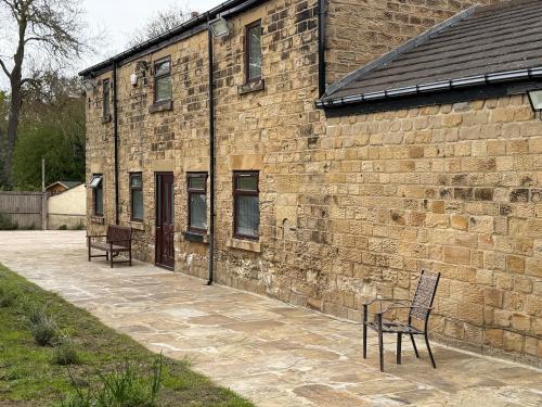 two chairs sitting outside of a brick building at Bethel Cottage in Oulton