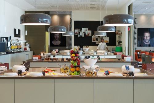 a kitchen with a counter with a chef in the background at Clarion Hotel Arlanda Airport Terminal in Arlanda