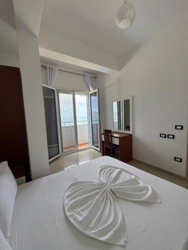 a bedroom with a white bed with a plate on it at Blue Paradise Hotel in Orikum
