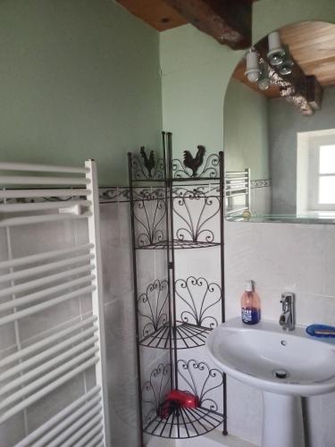 a bathroom with a sink and a toilet and a mirror at Charmante longère bretonne in Bourbriac