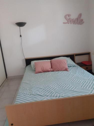 un lit avec un oreiller rose et une couette bleue dans l'établissement ipanema 006 le Capanna, au Cap d'Agde