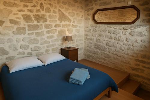 Un dormitorio con una cama azul en una pared de piedra. en Charmant LOFT, en Draguignan