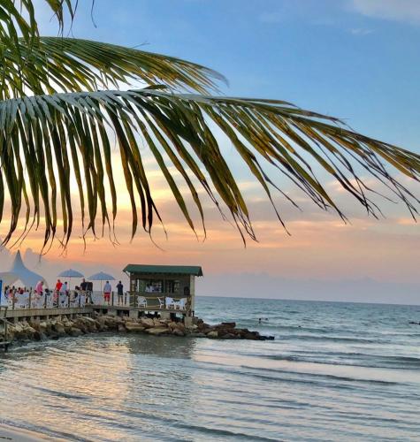 a group of people standing on a pier near the ocean at Hotel La Fragata in Coveñas