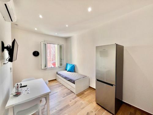 Cette petite chambre dispose d'une table et d'un réfrigérateur. dans l'établissement Bilocale Riviera-Menton centro, à Menton
