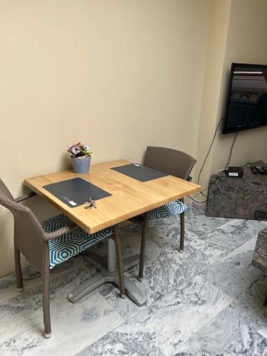 a wooden table with two chairs and a television at B&B Don Genaro in Dilsen-Stokkem