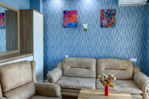 a living room with a couch and a chair at Hotel Sunny in Batumi