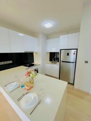 a white kitchen with two plates on a counter at Suites Apartment By Star Residences in Kuala Lumpur