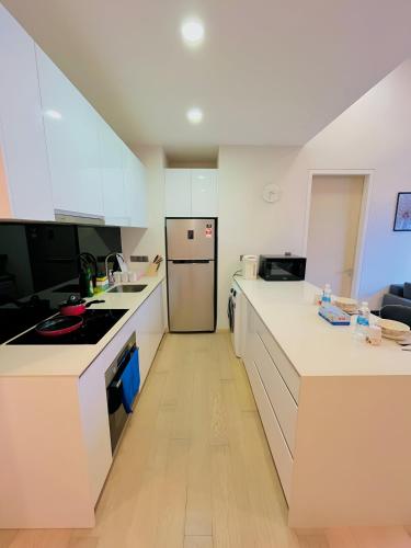 a kitchen with white counters and a refrigerator at Suites Apartment By Star Residences in Kuala Lumpur