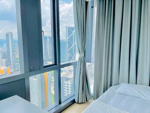 a bedroom with two beds and a large window at Suites Apartment By Star Residences in Kuala Lumpur