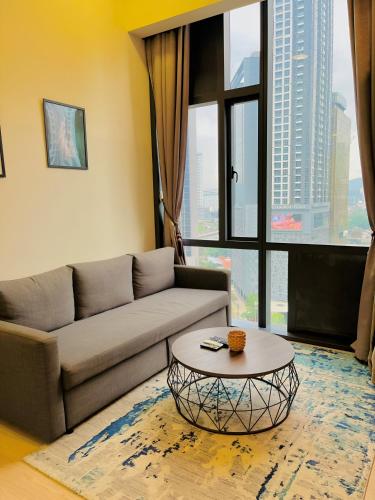 a living room with a couch and a table at Suites Apartment By Star Residences in Kuala Lumpur