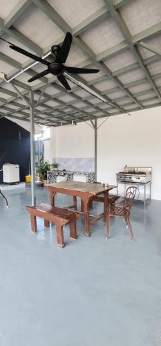 バヤンレパスにあるUmmi Studio Homestayのシーリングファン付きの客室で、テーブルとベンチが備わります。