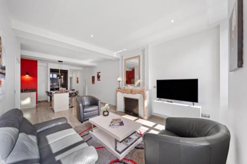 un salon avec un canapé et une télévision dans l'établissement Le Beau Carnot - Appartement en Hypercentre de Beaune, à Beaune