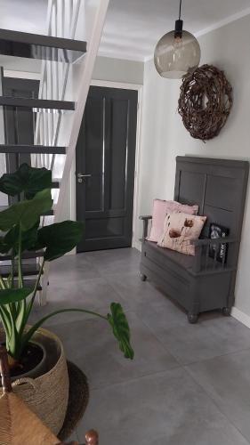 a living room with a couch and a plant at B&B Moria in Surhuisterveen