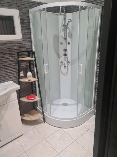 une douche avec une porte vitrée dans une salle de bain dans l'établissement chez Jordan logement Mirepoix 09 Vacance, à Mirepoix