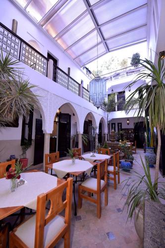 a restaurant with tables and chairs in a building at RIAD KALE POLIS in Marrakech