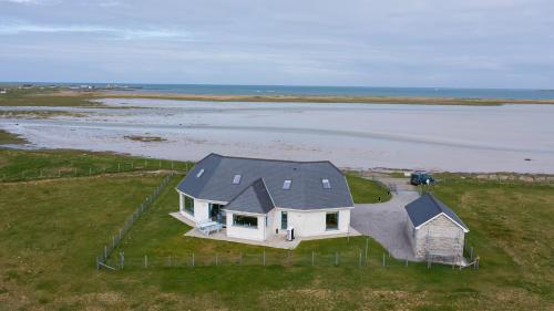 an aerial view of a house on the beach at Gualan Sands in Clachan