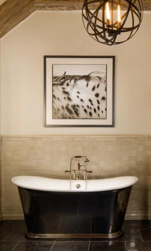 a bath tub in a bathroom with a chandelier at Eleven Scarp Ridge Lodge in Crested Butte