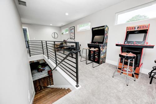 a room with two arcade games and a staircase at Indy Getaway - 5BR - Sleeps 16 - Arcade games - Perfect for families and groups in Indianapolis