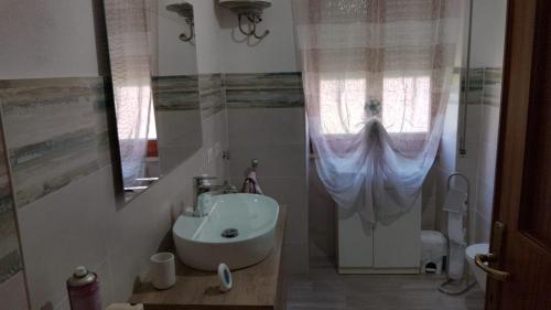 ボーザにあるFamily apartmentの洗面台と窓のあるバスルーム