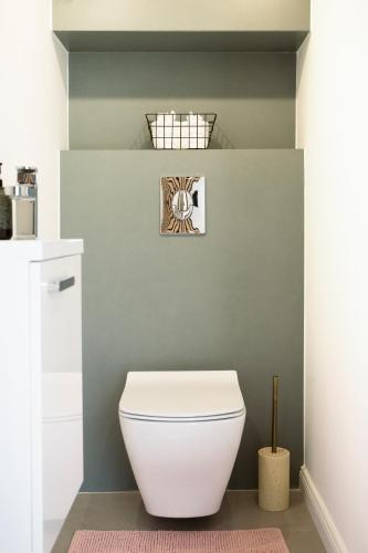 a bathroom with a white toilet in a room at Bovi Lux Apartman in Nyíregyháza