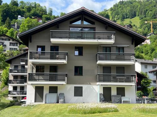 an apartment building with balconies and a yard at Hotel Belmont in Engelberg