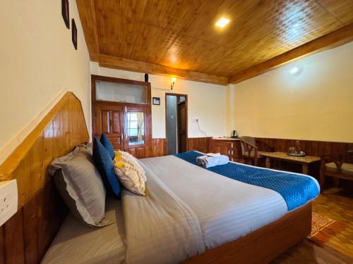 a bedroom with a large bed in a room at Sharda House in Manāli
