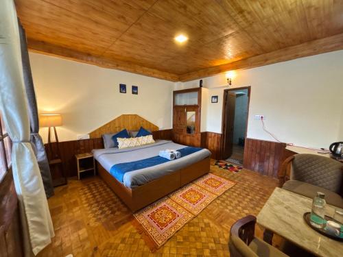 a bedroom with a bed and a couch in a room at Sharda House in Manāli