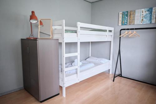 a white bunk bed with a desk and a lamp at Spacious Flat by the Rhine Ideal for Groups in Neuss