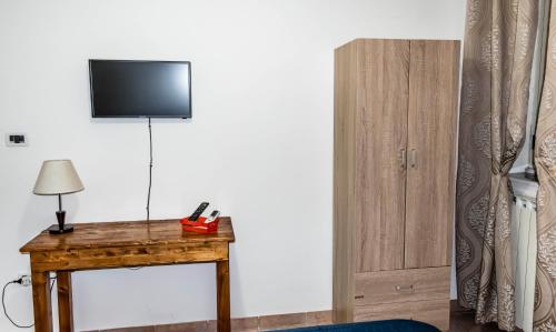 a room with a table with a television on a wall at La Culla B&B in SantʼEufemia Lamezia
